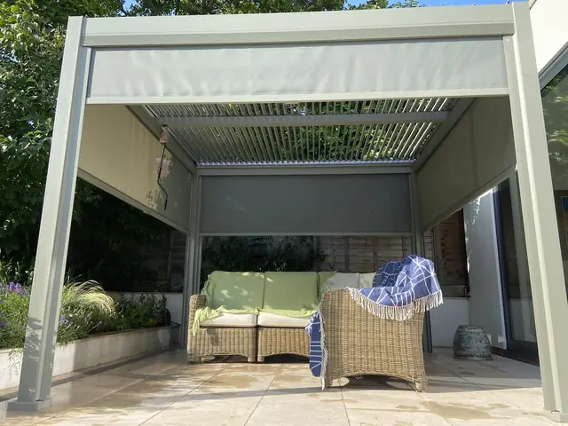 Finished patio area under a covered pergola with garden furniture