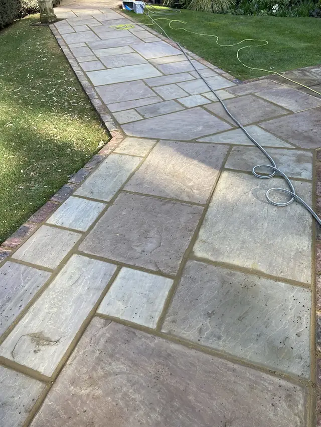 Grey sandstone paving laid in a random pattern